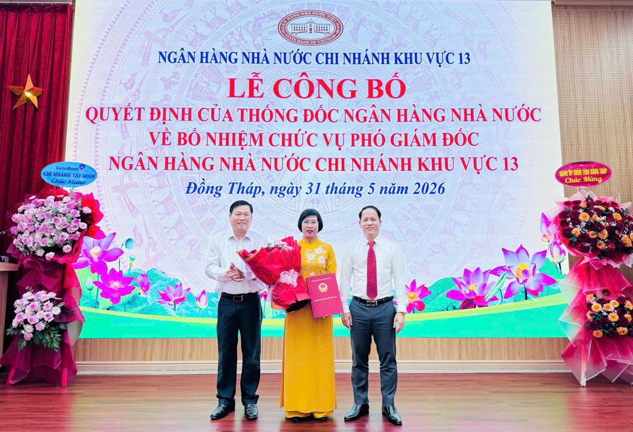 Ông Phạm Văn An (bìa trái), Phó Bí thư Đảng uỷ UBND tỉnh Đồng Tháp và ông Phạm Minh Tú - Giám đốc NHNN chi nhánh Khu vực 13 trao Quyết định bổ nhiệm giữ chức vụ Phó Giám đốc NHNN Khu vực 13 và tặng hoa chúc mừng bà Bùi Thị Thúy Hằng 
